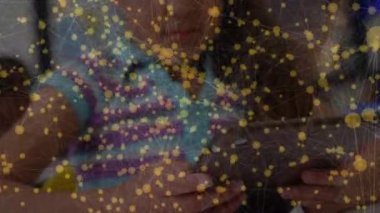 Sınıfta tablet kullanarak kız öğrencinin üzerinden geçen bağlantı ağının animasyonu. küresel iletişim teknolojisi, okul, eğitim ve öğrenim konsepti dijital olarak oluşturulmuş video.