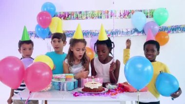 Doğum günü pastasında mum üfleyen ve partide parti veren çocukların animasyonu. çocukluk, parti ve kutlama konsepti dijital olarak oluşturulmuş video.