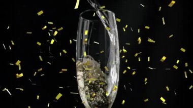 Siyah arka planda bir bardak şampanyanın üzerine düşen altın konfetilerinin animasyonu. kutlama ve yeni yıl partisi konsepti dijital olarak oluşturulmuş video.