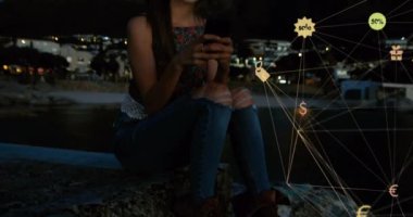 Akşamları açık havada akıllı telefon kullanarak beyaz ırka karşı dönen dijital simgeler küresi. küresel ağ ve teknoloji kavramı
