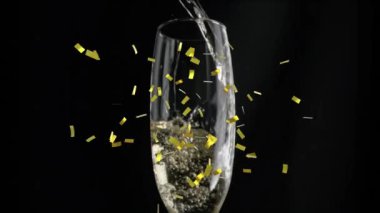 Siyah arka planda bir bardak şampanyanın üzerine düşen altın konfetilerinin animasyonu. kutlama ve yeni yıl partisi konsepti dijital olarak oluşturulmuş video.