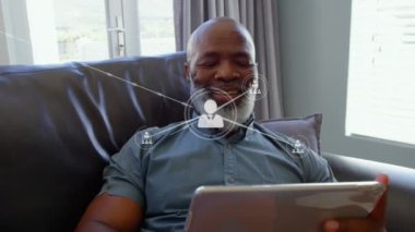 Tablet kullanan insanın üzerindeki simgelerle bağlantı ağlarının animasyonu. küresel teknoloji, dijital arayüz ve bağlantılar konsepti dijital olarak oluşturulmuş video.