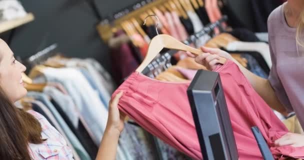 Duas Mulheres Caucasianas Sorrindo Segurando Shirt Comprar Roupas Loja Moda — Vídeo de Stock