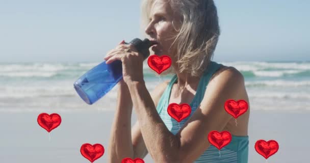Анимация Красных Сердечных Шаров Поднимающихся Над Женщиной Пьющей Воду Пляже — стоковое видео