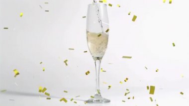 Beyaz arka planda bir bardak şampanyanın üzerine düşen altın konfetilerinin animasyonu. kutlama ve yeni yıl partisi konsepti dijital olarak oluşturulmuş video.