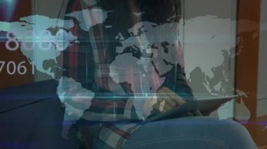 Dijital tablet kullanan bir kadına karşı dünya haritasında birden fazla değişen numara ve veri işleme sistemi. küresel ağ ve iş teknolojisi kavramı