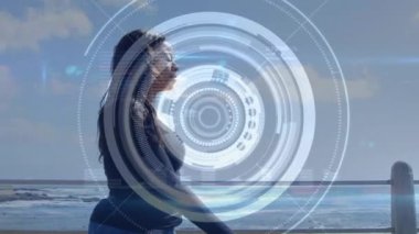Sahilde yürüyen yapay bacaklı bir kadının üzerinde dürbün taraması. fitness, engellilik, refah ve veri işleme konsepti dijital olarak oluşturulmuş video.
