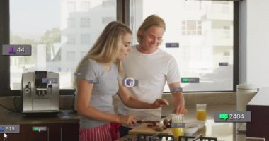 Güneşli mutfakta kahvaltı hazırlayan gülümseyen çiftin sosyal medya bildirimlerinin animasyonu. Sosyal medya ve küresel iletişim arayüzü teknolojisi kavramı dijital olarak oluşturulmuş video.