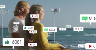 Sosyal medya simgelerinin deniz kenarındaki mutlu çiftler üzerinde canlandırılması. küresel sosyal medya, bağlantılar, dijital arayüz ve teknoloji konsepti dijital olarak oluşturulmuş video.