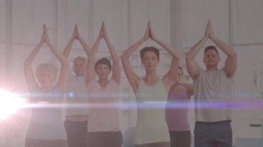 Yoga yapan insanların üzerinde parlayan ışığın animasyonu. fitness ve sağlıklı yaşam tarzı konsepti dijital olarak oluşturulmuş video.