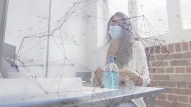 Ofisteki yüz maskesi takan iş kadınlarıyla bağlantılı ağların animasyonu. küresel iş, bağlantılar, veri işleme covid 19 salgın konsepti dijital olarak oluşturulmuş video.