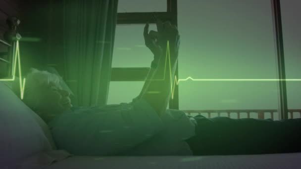 빛나는 심박수 모니터와 데이터의 애니메이션으로 침대에 나이든 스마트폰을 사용하고 있습니다 — 비디오
