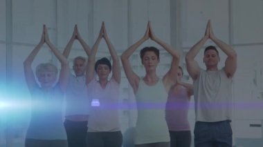 Yoga yapan insanların üzerinde parlayan ışığın animasyonu. fitness ve sağlıklı yaşam tarzı konsepti dijital olarak oluşturulmuş video.