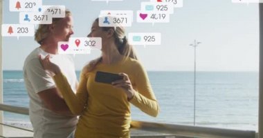 Deniz kenarında selfie çeken gülümseyen bir çiftin sosyal medya bildirimleri. Sosyal medya ve küresel iletişim arayüzü teknolojisi kavramı dijital olarak oluşturulmuş video.