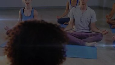 Yoga yapan insanların üzerinde parlayan ışığın animasyonu. fitness ve sağlıklı yaşam tarzı konsepti dijital olarak oluşturulmuş video.