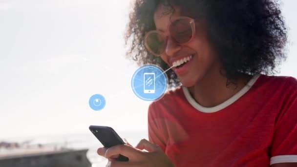 Sieć Ikon Cyfrowych Przeciwko Afrykańskiej Amerykance Używającej Smartfona Plaży Koncepcja — Wideo stockowe