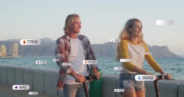 Deniz kenarında tatilde scooter kullanan gülümseyen bir çiftin sosyal medya bildirimleri. Sosyal medya ve küresel iletişim arayüzü teknolojisi kavramı dijital olarak oluşturulmuş video.