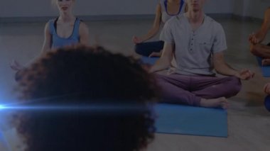 Yoga yapan insanların üzerinde parlayan ışığın animasyonu. fitness ve sağlıklı yaşam tarzı konsepti dijital olarak oluşturulmuş video.
