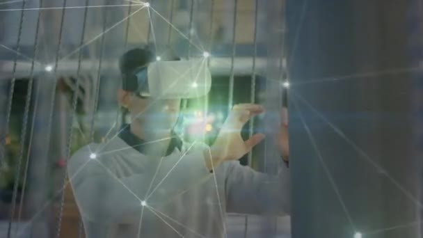 Vrヘッドセットを身に着けている男の上の接続のネットワークのアニメーション 世界規模の接続 データ処理 デジタルインターフェース テクノロジーの概念がデジタルで生成されたビデオ — ストック動画