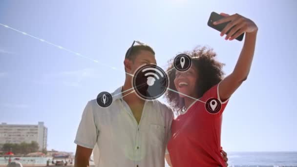 Sieć Ikon Cyfrowych Przeciwko Mieszanej Parze Rasowej Robiącej Selfie Smartfona — Wideo stockowe