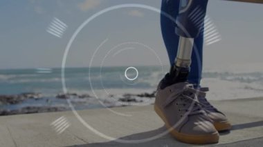 Sahilde duran yapay bacaklı bir kadının üzerinde dürbün taraması. fitness, engellilik, refah ve veri işleme konsepti dijital olarak oluşturulmuş video.