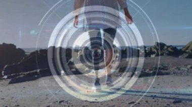 Sahilde yürüyen yapay bacaklı bir kadının üzerinde dürbün taraması. fitness, engellilik, refah ve veri işleme konsepti dijital olarak oluşturulmuş video.