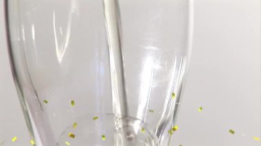 Beyaz arka planda şampanya bardağının üzerine düşen konfeti animasyonu. parti ve kutlama konsepti dijital olarak oluşturulmuş video.