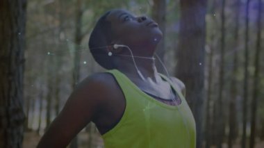Ormanda egzersiz yapan bir kadın üzerindeki bağlantı ağının animasyonu. küresel bağlantılar, fitness, refah konsepti dijital olarak oluşturulmuş video.