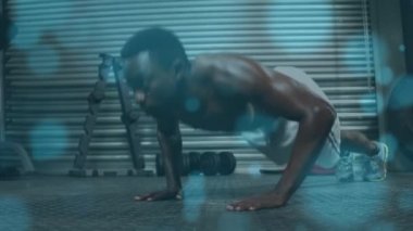 Spor salonunda egzersiz yapan zinde bir adamın üzerinde parlayan ışığın animasyonu. global spor, fitness ve veri işleme konsepti dijital olarak oluşturulmuş video.