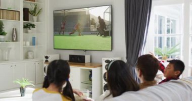 Mutlu bir ailenin evde oturup TV 'de hokey maçı izlemesinin birleşimi. spor, rekabet, eğlence ve teknoloji konsepti dijital olarak oluşturulmuş video.