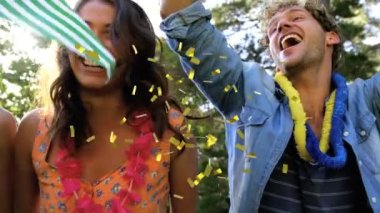 Müzik konserinde eğlenen kalabalığın üzerine düşen altın konfetilerin animasyonu. yaz, tatil, kutlama, müzik ve parti konsepti dijital olarak oluşturulmuş video.