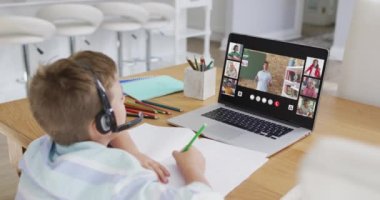 Liseli çocuk evde online ders için dizüstü bilgisayar kullanıyor. Çeşitli öğretmenler ve sınıflar ekranda. küresel iletişim teknolojisi ve çevrimiçi ilköğretim konsepti, dijital kompozit video.