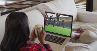 Evde oturup dizüstü bilgisayarda hokey maçı izleyen bir kadın resmi. spor, rekabet, eğlence ve teknoloji konsepti dijital olarak oluşturulmuş video.