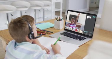 Öğrenci, meslektaşı ve internet sohbeti ile evde online ders için dizüstü bilgisayar kullanıyor. küresel iletişim teknolojisi ve çevrimiçi ilköğretim konsepti, dijital kompozit video.