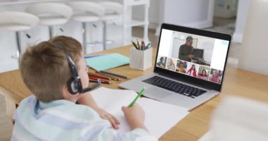 Evde online ders için dizüstü bilgisayar kullanan çocuğun kompozitifi, ekranda çeşitli öğretmenler ve sınıflar var. küresel iletişim teknolojisi ve çevrimiçi ilköğretim konsepti, dijital olarak oluşturulmuş video.