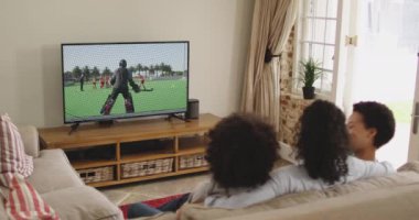 Mutlu bir ailenin evde oturup TV 'de hokey maçı izlemesinin birleşimi. spor, rekabet, eğlence ve teknoloji konsepti dijital olarak oluşturulmuş video.