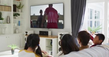 Mutlu bir ailenin evde oturup TV 'de hokey maçı izlemesinin birleşimi. spor, rekabet, eğlence ve teknoloji konsepti dijital olarak oluşturulmuş video.