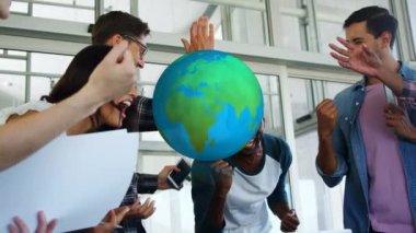 Sıradan ofis toplantılarında kutlama yapan farklı meslektaşlar üzerinde dönen dünyanın animasyonu. Dijital olarak oluşturulan küresel iletişim ağı konsepti.