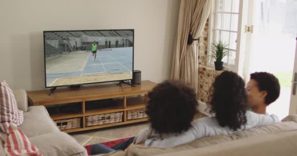 Compuesto Familia Feliz Sentados Casa Juntos Viendo Atletismo Salto Largo — Vídeo de stock