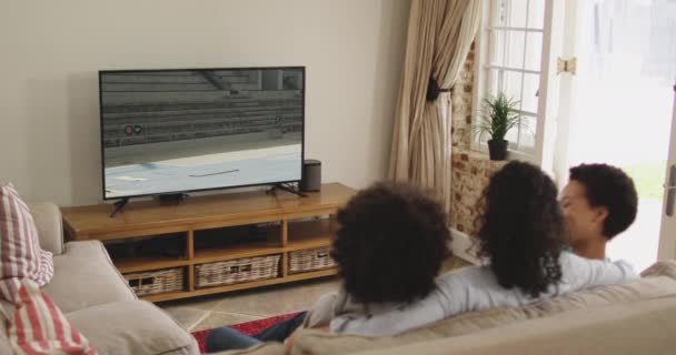 Composto Família Feliz Sentados Casa Juntos Assistindo Atletismo Salto Distância — Vídeo de Stock