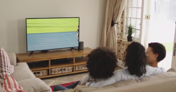 Mutlu Bir Ailenin Evde Oturup Televizyonda Spor Müsabakalarını Izlemesinin Birleşimi — Stok video