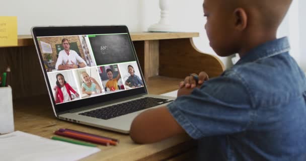 ラップトップを使用して少年の複合ビデオ オンラインレッスンで 画面上の多様な教師とクラス 地球規模の通信技術とオンライン初等教育の概念デジタルで生成されたビデオ — ストック動画