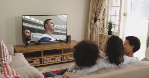 Kompozyt Szczęśliwej Rodziny Siedzącej Razem Domu Oglądając Mecz Rugby Telewizji — Wideo stockowe