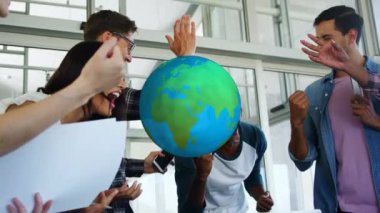 Sıradan ofis toplantılarında kutlama yapan farklı meslektaşlar üzerinde dönen dünyanın animasyonu. Dijital olarak oluşturulan küresel iletişim ağı konsepti.