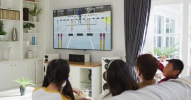 Mutlu bir ailenin evde oturup spor müsabakalarını izlemesinin birleşimi. spor, rekabet, eğlence ve teknoloji konsepti dijital olarak oluşturulmuş video.