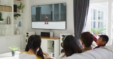 Mutlu bir ailenin evde oturup spor müsabakalarını izlemesinin birleşimi. spor, rekabet, eğlence ve teknoloji konsepti dijital olarak oluşturulmuş video.