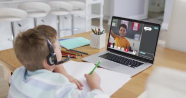 Okullu çocuk evde online ders için dizüstü bilgisayar kullanıyor. Okul arkadaşı ve internette sohbet ediyor. küresel iletişim teknolojisi ve çevrimiçi ilköğretim konsepti, dijital kompozit video.