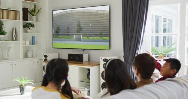 Kompozyt Szczęśliwej Rodziny Siedzącej Domu Razem Oglądającej Lekkoatletykę Oszczepem Telewizji — Wideo stockowe