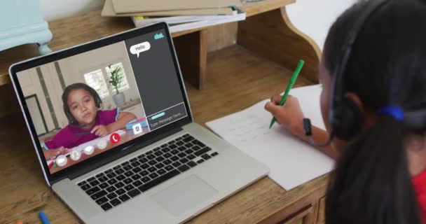家庭でのオンラインレッスンのためにラップトップを使用して女子高生 彼女の同僚と画面上のWebチャットと グローバルコミュニケーション技術とオンライン初等教育の概念デジタル複合ビデオ — ストック動画