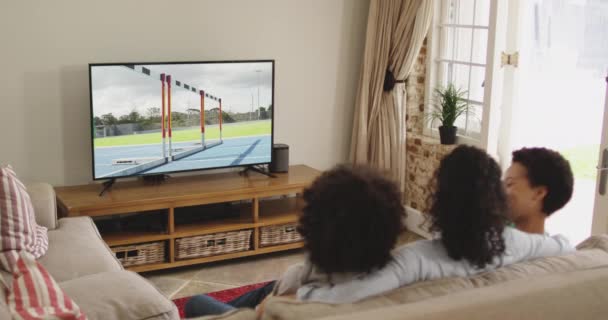Compuesto Familia Feliz Sentados Casa Juntos Viendo Correr Con Obstáculos — Vídeo de stock